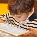 bambino che è assorto dal tablet